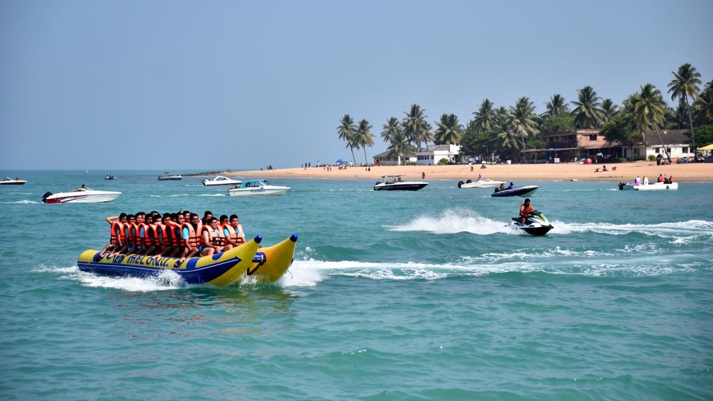 Jet ski cutting across turquoise water at Nagoa with a banana boat